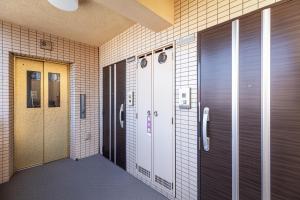a corridor of a building with two lockers and a door at 天神南参番館Tenjin Minami Hotel I Fukuoka Central I San Ban Kan in Fukuoka