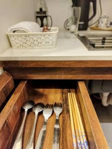 a drawer filled with wooden utensils on a kitchen counter at The Turquoise Letterbox - Twin at Central in Kolkata