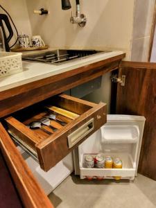 an open drawer in a kitchen with a sink at The Turquoise Letterbox - Twin at Central in Kolkata