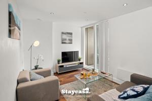 a living room with a couch and a glass table at Spectacular Apartment Balcony View In City Centre in Manchester