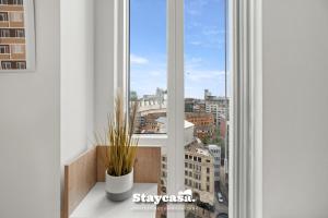 a window with a view of a city at Spectacular Apartment Balcony View In City Centre in Manchester