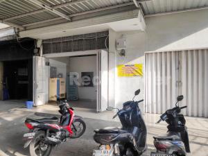 dos motocicletas estacionadas frente a un garaje en Ada Guest House Medan Redpartner, en Medan