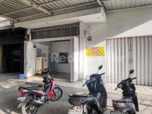 Dos motocicletas estacionadas frente a un garaje en Ada Guest House Medan Redpartner, en Medan