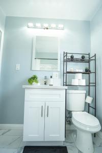 a white bathroom with a toilet and a mirror at Retreat Minutes To LAX, Manhattan/ Redondo Beach in Torrance