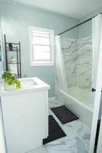 a bathroom with a tub and a sink and a shower at Retreat Minutes To LAX, Manhattan/ Redondo Beach in Torrance
