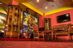 傑夫格里雅的住宿－參議員賭場汽車旅館，用餐室设有长凳和墙上的电视