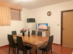 a dining room table with chairs and a television at Charming Apartment in Banjole near Sea in Banjole