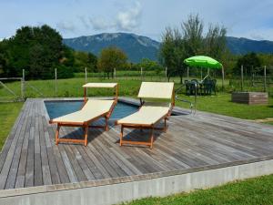 a deck with two benches and a green umbrella at Modern Farmhouse in Pagnano Italy near Forest in Asolo
