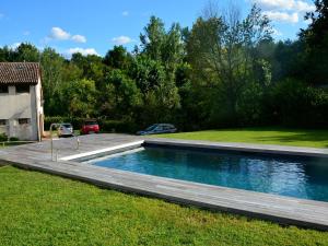 a swimming pool in a yard with a wooden deck at Modern Farmhouse in Pagnano Italy near Forest in Asolo