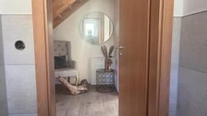 eine Tür zu einem Zimmer mit einem Stuhl und einem Spiegel in der Unterkunft Erholung pur für die ganze Familie in Ribnitz-Damgarten