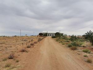 a dirt road leading to a house in the desert at Geelkop Plaashuis in Keimoes