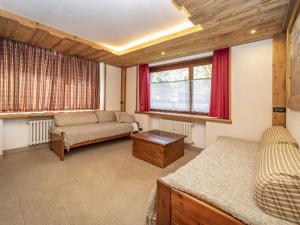 ein Wohnzimmer mit einem Sofa und einem Tisch in der Unterkunft Snug apartment in Sauze d Oulx with fenced garden in Sauze dʼOulx