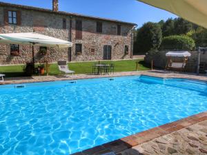 una piscina di fronte a una casa in pietra di Apartment on farm amidst the Umbrian hills a Todi