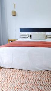 a large white bed with a red and white blanket at Tamarin River Villa in Tamarin