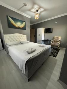 - une chambre avec un grand lit blanc et une chaise dans l'établissement Göl Otel, à Avcılar
