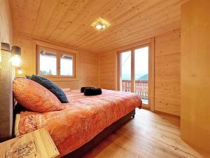 1 dormitorio con 1 cama en una habitación con ventanas en Chalet a Didi - Alps Paradise - 4 Vallees, en La Tzoumaz