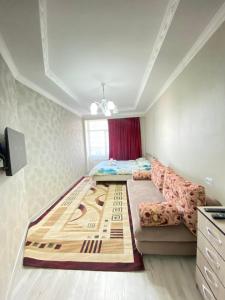 una piccola camera da letto con un letto e un divano di Atlantis a Bishkek
