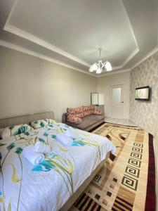 una camera da letto con un letto grande e un divano di Atlantis a Bishkek