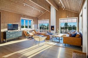 uma sala de estar com paredes e móveis de madeira e janelas em Villa Budor 1.5 time fra Oslo em Nordset