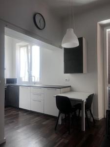a kitchen with a table and a clock on the wall at casa boutique in Ivrea