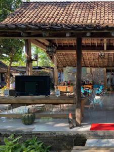 a wooden gazebo with a flat screen tv under it at Didu's Homestay Bed & Breakfast in Banyuwangi