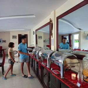 a man and a little girl standing in front of a counter at Zoé’s Paradise Waterfront Hotel in Tuk Tuk