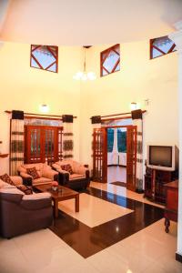 una gran sala de estar con sofás y TV. en Vision Home, en Ambalangoda