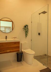 y baño con aseo, lavabo y espejo. en The Peak Surf House en Huu