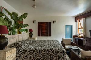 a bedroom with a bed and a potted plant at Casa Vagator in Vagator