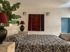 a bedroom with a large bed and a plant at Casa Vagator in Vagator