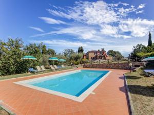 una piscina en un patio con sillas y sombrillas en Countryside Holiday Home in Gambassi Terme with Garden, en Querce