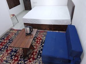 Schlafzimmer mit einem Bett und einem Holztisch in der Unterkunft Hotel Balaji Residency in Udaipur