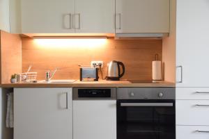 a kitchen with white cabinets and a sink and a stove at Charming Homes - Studio 25 in Wolfsburg