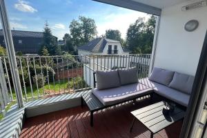 a balcony with a couch and a table at Luxus Wohnung Köln/Phantasialand/Bonn/ Messe in Wesseling