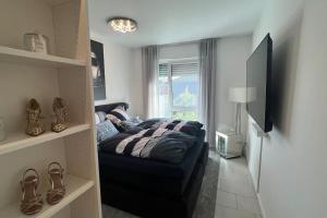 1 dormitorio con 1 cama y TV en Luxus Wohnung Köln/Phantasialand/Bonn/ Messe, en Wesseling