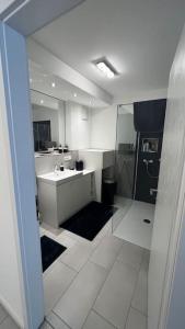 ein weißes Bad mit einem Waschbecken und einer Dusche in der Unterkunft Luxus Wohnung Köln/Phantasialand/Bonn/ Messe in Wesseling