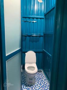 a blue bathroom with a toilet in a stall at VulunVili Homestay in Tây Ninh