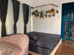 1 dormitorio con 1 cama y 1 silla en VulunVili Homestay en Tây Ninh