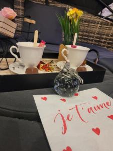 a table with two cups and a sign that says i wanna be drinking at fee moi rêver in Lallaing