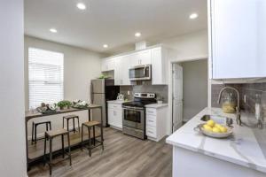 uma cozinha com armários brancos e uma bancada em San Jose Shark House - Unit 1 em San José