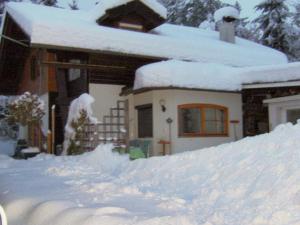 a house with a pile of snow in front of it at Holiday home in Wernberg with pool and sauna in Wernberg