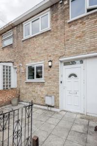 a brick building with a white garage door at Carlile House - London 5 bedroom Free Parking & Garden by Damask Homes in London