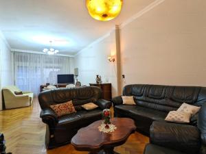 a living room with a leather couch and a table at Marietta in Debrecen