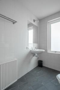 a white bathroom with a sink and a window at Hermanus Boexstraat in Eindhoven