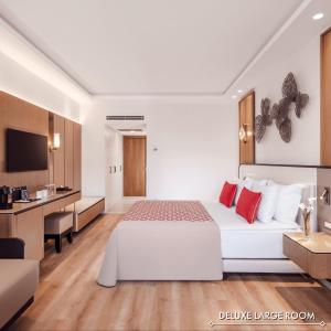 ベルディビにあるAkka Antedon Hotel - Premium Ultra All Inclusiveの白いベッドとデスクが備わるホテルルームです。