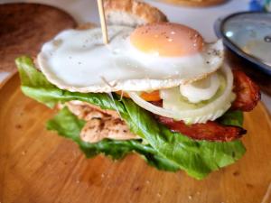 un sándwich con un huevo en un plato de madera en P168 Hostel Samui, en Chaweng