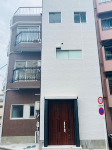 um edifício branco com uma porta e uma varanda em Shinjuku area/Family-apartment/4 min to Subway em Tóquio