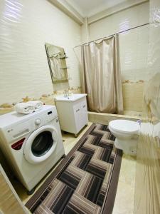 a bathroom with a washing machine and a toilet at Atlantis in Bishkek