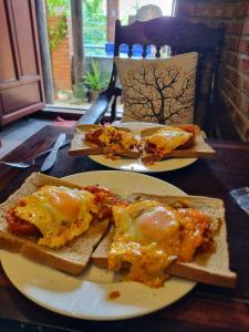 two plates of food on a table with eggs on toast at Calm House 2 HOSTEL in Hoi An