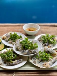 a tray with four plates of oysters and a bowl of soup at Calm House 2 HOSTEL in Hoi An